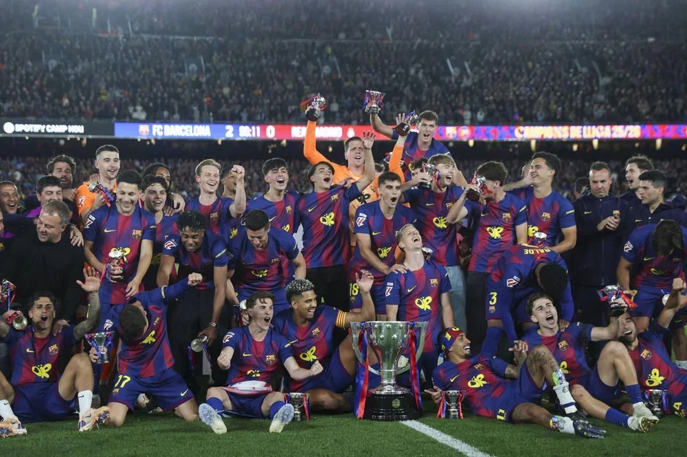 Hansi Flick (izquierda) y sus jugadores y staff técnico celebran la conquista del título de la Liga 2025/26 en el Spotify Camp Nou